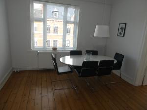 una sala da pranzo con tavolo, sedie e finestra di Bentzonsvej a Copenaghen