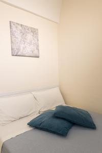 a bed with a blue pillow in a room at Casa Galliani Ostuni in Ostuni