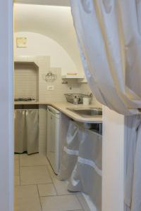 a kitchen with a sink and a dishwasher at Casa Galliani Ostuni in Ostuni