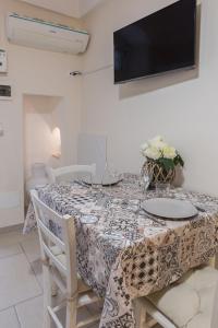 a dining room with a table and a tv on the wall at Casa Galliani Ostuni in Ostuni