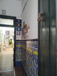 una puerta a una habitación con azulejos azules y amarillos en Apartamentos Fernando El Catolico, en Málaga