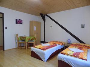 two beds in a room with a table and a chair at Ubytování Apartmány Ferenčíková in Nové Hrady +98 photos