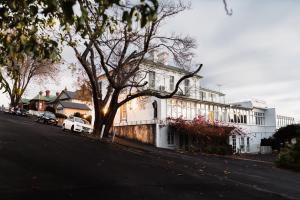 霍巴特巴特里帕恩特庄园住宿加早餐旅馆的街道边有树的白色房子