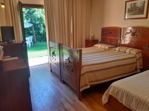 a bedroom with two beds and a sliding glass door at Relais Leon d'Oro in Mirano