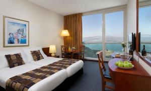a hotel room with a large bed and a desk with a desk at King Solomon Hotel Tiberias in Tiberias