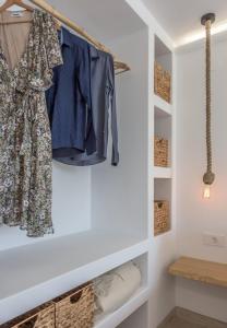 a walk in closet with a dress hanging on a rack at Michalakis Seaside Suites in Pollonia