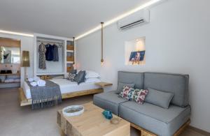 a living room with a couch and a bed at Michalakis Seaside Suites in Pollonia