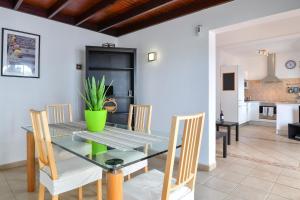 Un comedor con una mesa de cristal y sillas. en Villa Gauda, en Playa Blanca