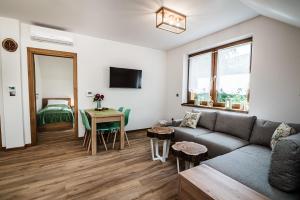 ein Wohnzimmer mit einem Sofa und einem Tisch in der Unterkunft Domki nad Stawami in Ujanowice