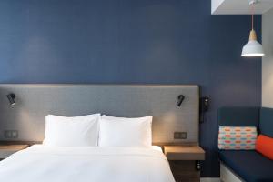 珠海的住宿－珠海拱北智选假日酒店，一间卧室设有一张大床和蓝色的墙壁
