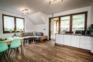 a kitchen and living room with a couch and a table at Domki nad Stawami in Ujanowice