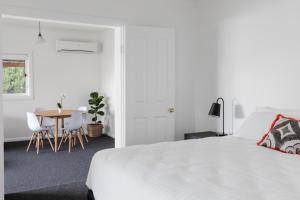 1 dormitorio con 1 cama, mesa y sillas en Battery Point Manor en Hobart