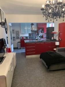 マントンにあるAppartement Moderne Borrigoの広いキッチン(赤いキャビネット、ベッド付)