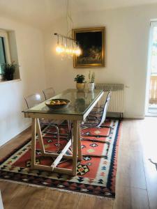 a dining room with a table and chairs on a rug at Ferienwohnung Attersee-Mondsee in Unterach am Attersee