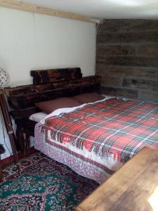 um quarto com uma cama e uma parede de tijolos em Castaway Cabin em Tuamgraney