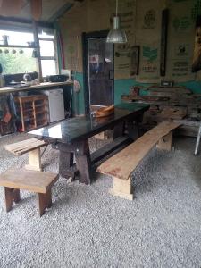 uma grande mesa de madeira e bancos num quarto em Castaway Cabin em Tuamgraney