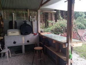 a outdoor kitchen with a stove and a bar at Castaway Cabin in Tuamgraney