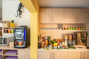 a kitchen with a microwave and a counter with food at ibis Styles Beaulieu sur Mer in Beaulieu-sur-Mer