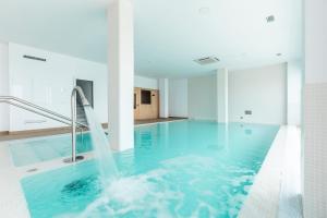 a swimming pool with a water fountain in a building at Apartamentos Martalia Nerja in Torrox