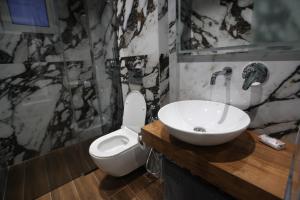 a bathroom with a white toilet and a sink at Vila Neli in Ksamil