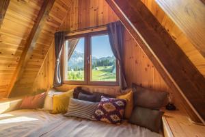 a bed in a room with a window at Chamois Apartments Durmitor in Žabljak