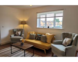 a living room with a couch and two chairs at Private Spacious 2 Bedroom, 2 Bathroom & 2 Parking by Srk Accommodation in Peterborough