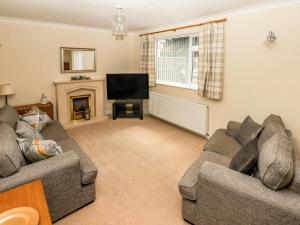 a living room with two couches and a television at Spring Close in Southport