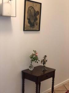 a table with two vases and a picture on a wall at Allesø Gl. sognefoged gård in Odense