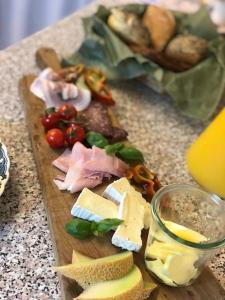 a cutting board with cheese and vegetables on a table at Allesø Gl. sognefoged gård in Odense