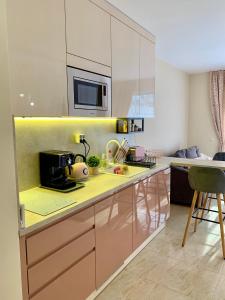 eine Küche mit einer gelben Arbeitsplatte und einer Mikrowelle in der Unterkunft Beige-a-view, Sea Dreams in Sweti Wlas