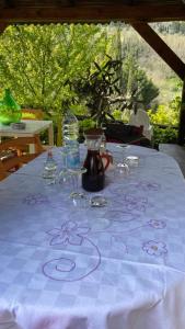 una mesa con un mantel blanco con flores púrpuras. en B&B la Concordia, en Serravalle Pistoiese