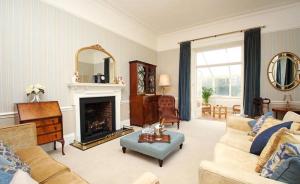 a living room with a couch and a fireplace at Bressingham Hall in Bressingham