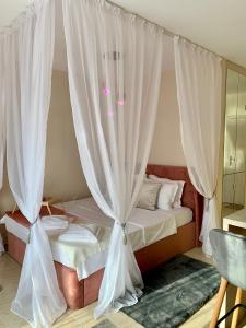 Schlafzimmer mit Himmelbett und weißen Vorhängen in der Unterkunft Beige-a-view, Sea Dreams in Sweti Wlas