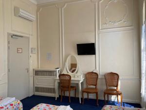 Habitación con tocador, sillas y espejo. en Hôtel Belle Meunière, en Niza