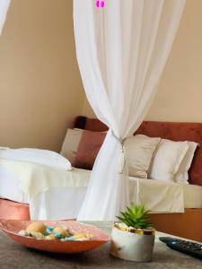 ein Schlafzimmer mit einem Bett und einer Obstschale auf einem Tisch in der Unterkunft Beige-a-view, Sea Dreams in Sweti Wlas