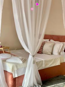 Schlafzimmer mit einem Bett mit Vorhang in der Unterkunft Beige-a-view, Sea Dreams in Sweti Wlas