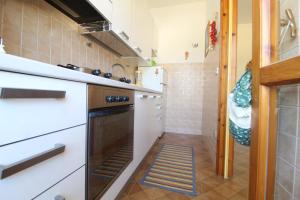 una pequeña cocina con armarios blancos y lavavajillas en Gallipoli via Dante en Gallipoli