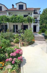 a house with a garden with flowers in front of it at Apartments Budva Center in Budva