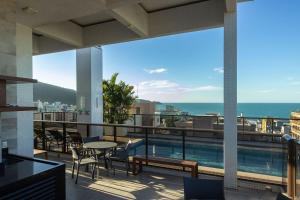 Un balcón con piscina y vista al mar. en San Diego, en Bombinhas