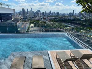 a swimming pool with a view of the city at Siamese Exclusive Queens in Bangkok