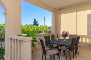 a patio with a table and chairs on a balcony at Apartments Ella in Supetar