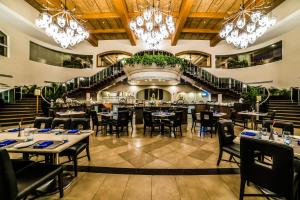 un restaurante con mesas y sillas y una escalera en The Zuri White Sands, Goa Resort & Casino, en Varca