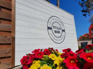 a sign on the side of a building with flowers at Apartamenty Stella Mare - 365PAM in Ustronie Morskie