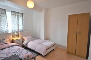 een slaapkamer met 2 bedden en een kast bij London Zone 1 Lovely 3bedroom Maisonette Apartment in Londen