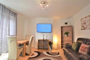 a living room with a couch and a table and a tv at London Zone 1 Lovely 3bedroom Maisonette Apartment in London
