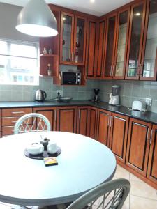 a kitchen with a white table with chairs and cabinets at Joans place selfcatering in Velddrif