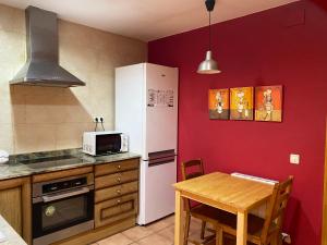 cocina con nevera blanca y mesa en La Polaina, en Montblanc