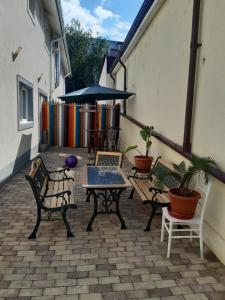 a patio with benches and a table and an umbrella at Apartament 2 camere - Casa Divertis in Buzau