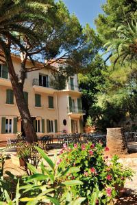 un edificio con un albero e dei fiori rosa di VTF Clairefont a Bandol