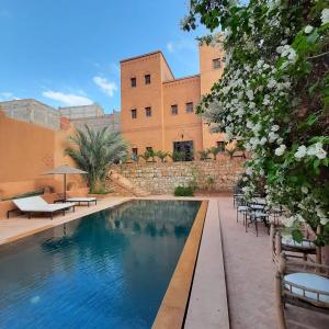 a swimming pool in front of a building at Riad Bouchedor in Ouarzazate